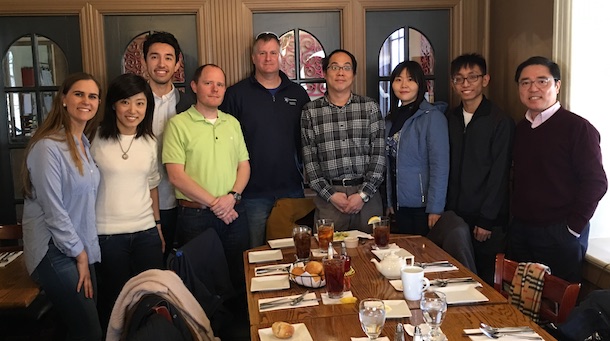 Group of people posing for a photo around a lunch table